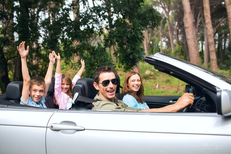 happy family on vacation in rented convertible