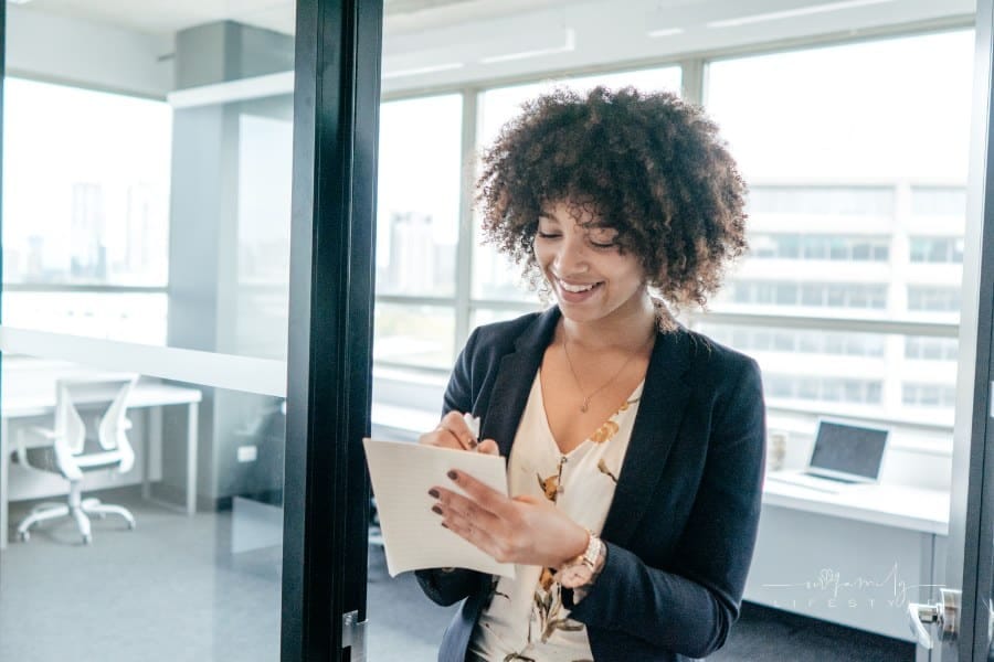 Business woman smiling while taking paper notes