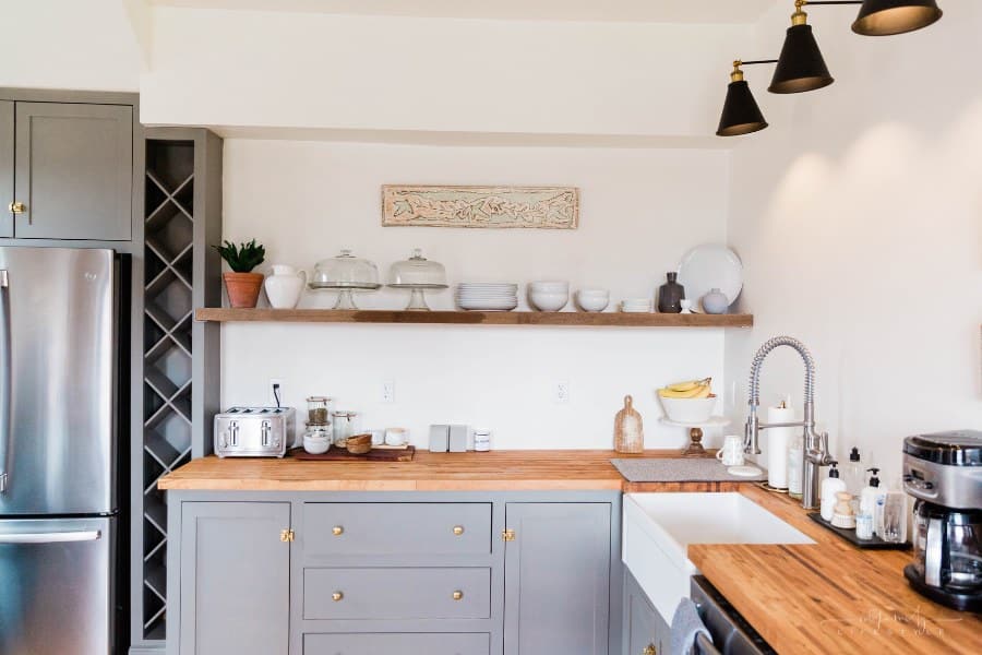 modern kitchen with open shelving, stainless steel refrigerator, and gray cabinets