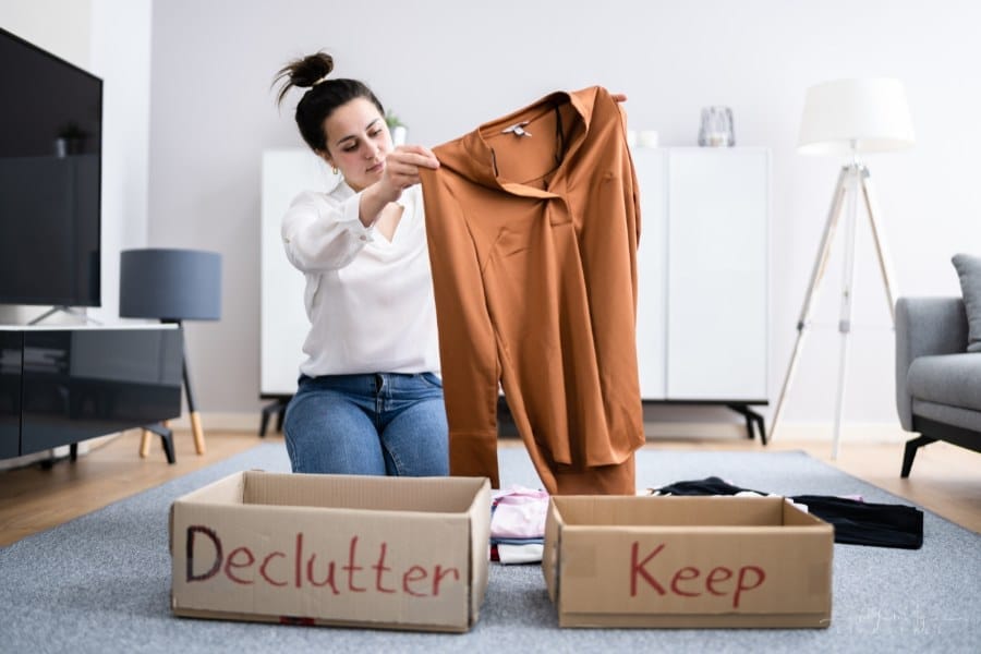 woman sorting clothes to declutter or keep
