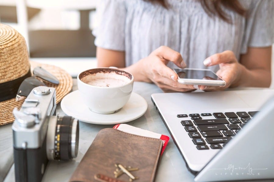 woman on both phone and laptop planning travel