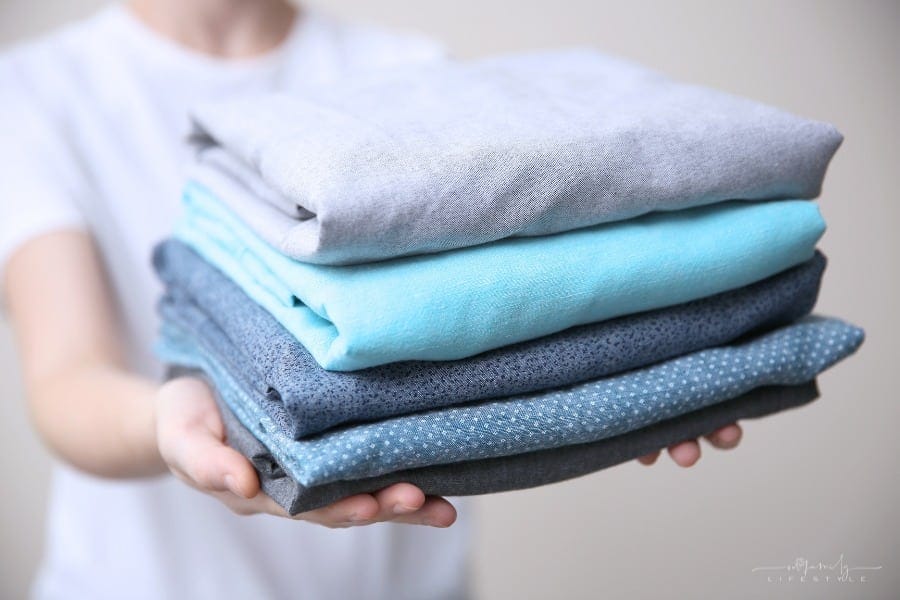 stacked of folded blue-tone clothes