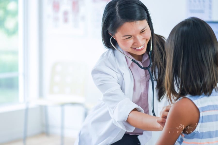 Female pediatrician listening to female patient’s heart