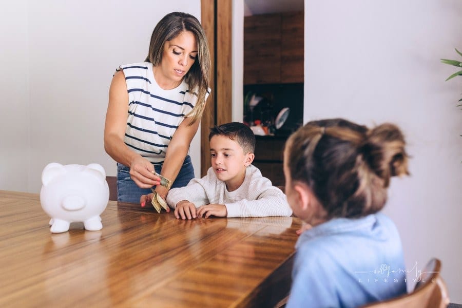 Mother Giving Money to Children for Piggy Bank