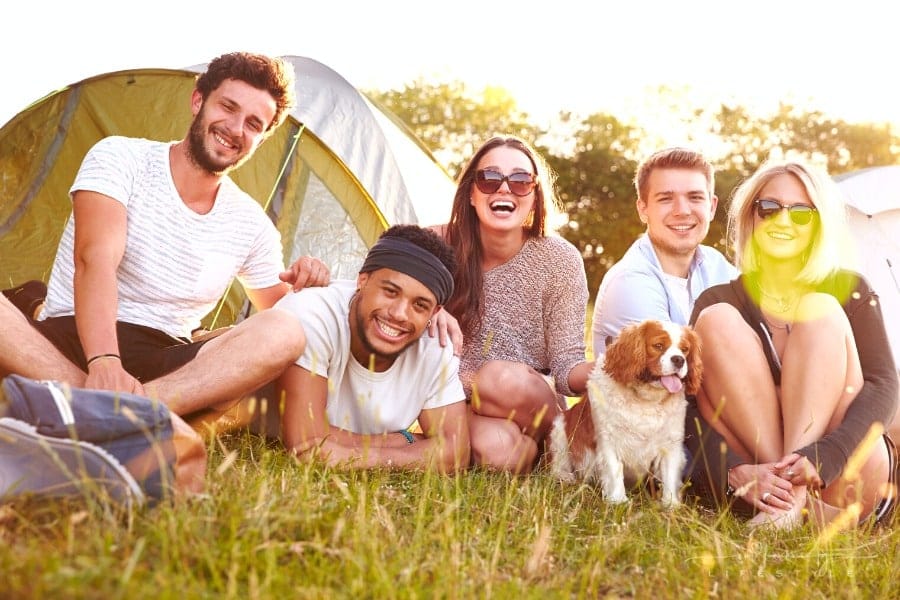 friends laughing outside of tent while camping