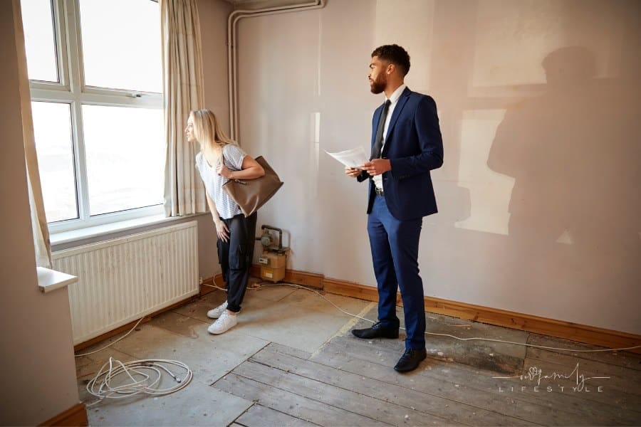 Woman looking at house in need of repair with realtor