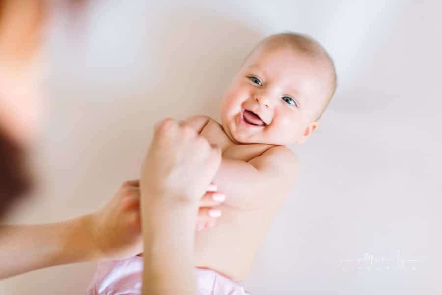 Baby massage. Mother massaging and doing gymnastic with arms of her kid