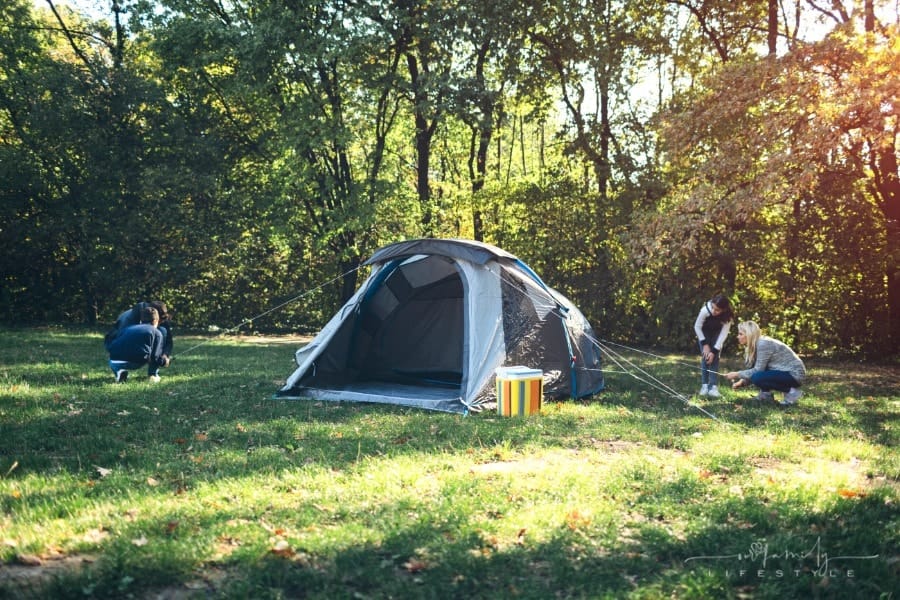 family putting a camping tent up together