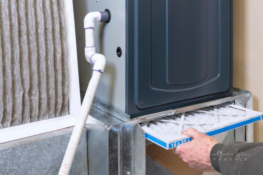Man replacing dirty furnace filter in home